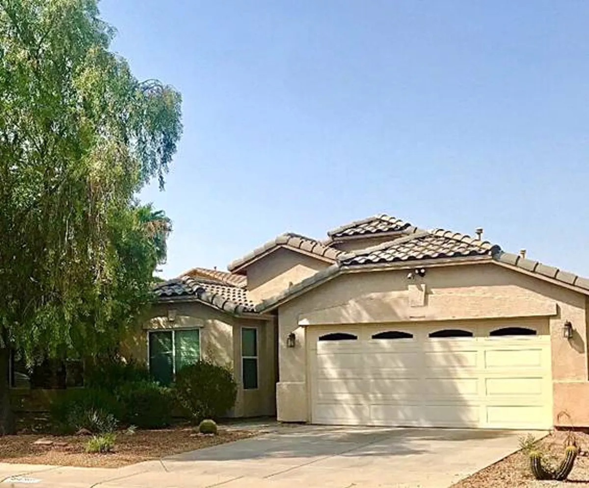 This exterior image showcases the front door, garage, and landscaped yard of the property bathed in welcoming light. The space is inviting, suggesting arrival and the start of group gatherings. The well-maintained yard hints at outdoor activities and curb appeal, setting the stage for friends or family reunions.